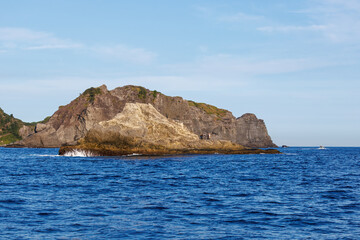 Fototapeta premium 沖磯に釣人がいる。 夕暮れの海に漁船に乗ってアカハタ釣りに出かけた。 ヒリゾ浜南伊豆町中木 静岡県伊豆半島-2025 日本有数のシュノーケリングスポット。 夏の数カ月間だけ渡し船で行ける。 水質透明度魚影が素晴らしい。 