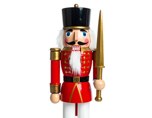 A wooden toy soldier with a red coat, black hat, and gold sword on a black background