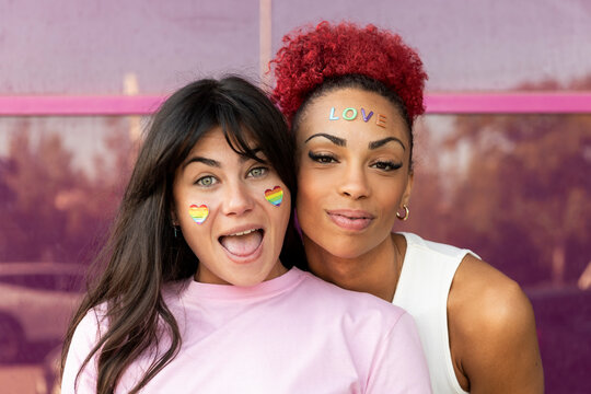 Friends near purple background with fashion sticker on face