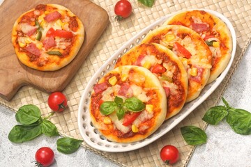 Homemade mini pizzas with smoked beef, tomatoes and mozzarella cheese