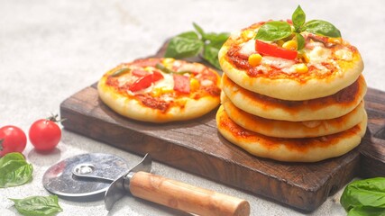 Homemade mini pizzas with smoked beef, tomatoes and mozzarella cheese