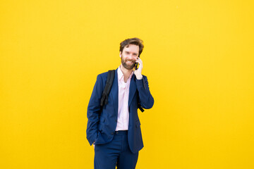 Businessman on smartphone against yellow background
