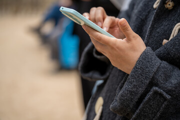 Close-up of an unrecognizable woman using a smartphone in the city