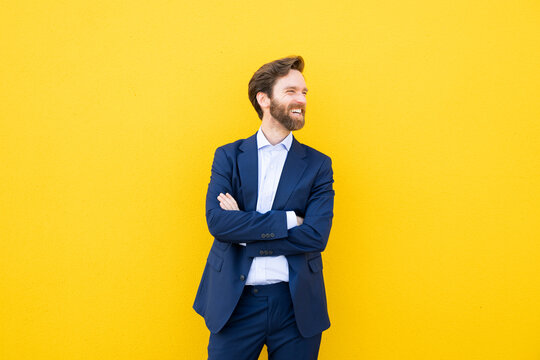 Smiling businessman with suit against yellow background