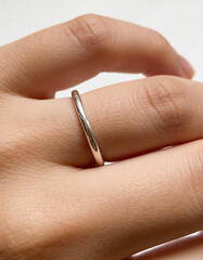 Macro Close-Up of Human Hand Wearing Minimal Silver Ring with Shallow Depth of Field, Clean Studio Background, Premium Jewelry Concept for Modern Luxury Branding and Elegant Visual Design