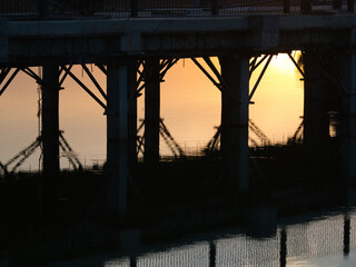 The bridge across the pond in the morning is under construction.