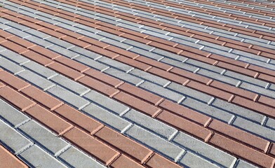 Gray and red rectangle concrete tiles for outdoor pavement or sidewalk. Striped pattern, background and texture.