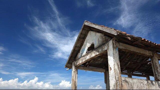 An abandoned house under a blue sky with beautiful clouds.