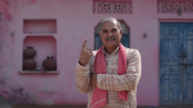 senior indian farmer showing voting sign