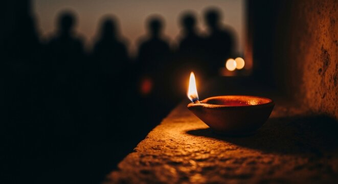 Burning clay oil lamp in the dark with silhouettes of people in the background. Concept of faith, hope, and the Parable of the Ten Virgins. Traditional Diya for Diwali or religious vigil. Copy space
