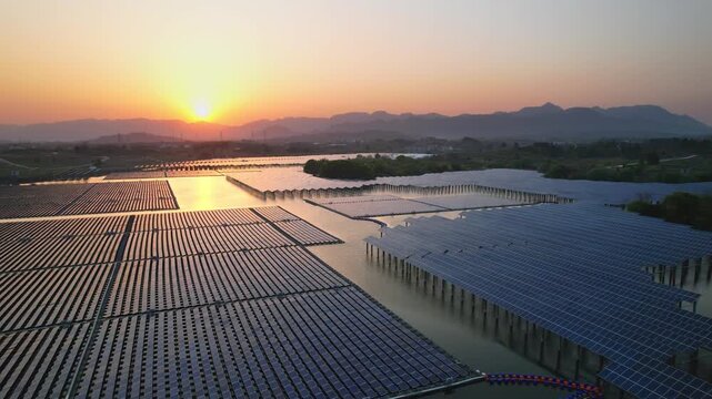Large photovoltaic power station array at sunset with distant mountains and lakes