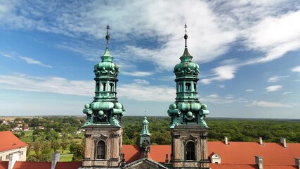 Aerial drone view of Cistercian Abbey in Lubiąż, Lower Silesia, Poland, surrounded by lush green forests, river, and scenic countryside landscape, historic monastery and cultural heritage site 