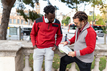 Two friends consulting the city's tourist map during their vacation