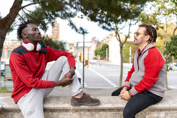 Diverse men friends having a tense conversation outdoors in a cityscape