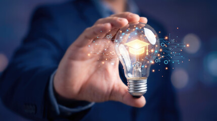 A person in a suit holds a glowing lightbulb in their hand against a dark background with indistinct bright spots of light