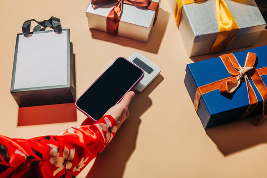 Payment by mobile phone near gift boxes for holiday shopping
