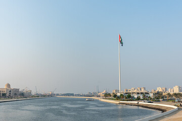 The Flag Island, Sharjah, UAE,10.10.2025. A large flagpole stands with the UAE flag flying high above the water. © Павел Чепелев