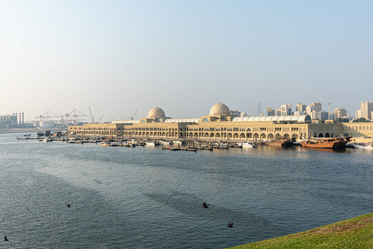 Souq Al Jubail, Sharjah, UAE,10.10.2025. Market with multiple boats docked near a series of large buildings.
