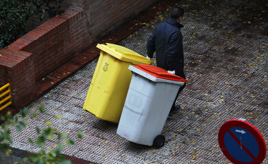 Portero sacando los cubos y contenedores de basura