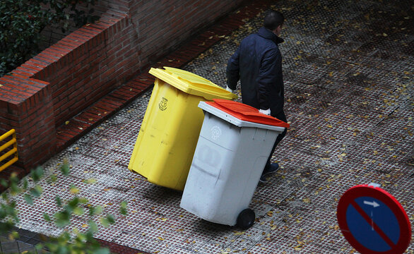 Portero sacando los cubos y contenedores de basura