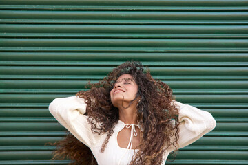 Obraz premium Happy young woman enjoying freedom with curly hair