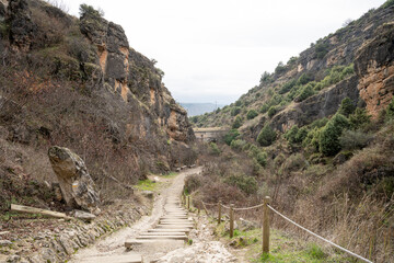 A winding path through rocky hills and greenery.. Pueblo de Patones de Arriba in Madrid, known for...