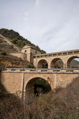 Obraz premium Historic stone bridge structure in a mountainous area.. Pueblo de Patones de Arriba in Madrid, known for its slate architecture and for evading the French invasion.
