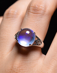 Macro Close-Up of Human Hand Wearing Transparent Gemstone-Style Ring with Futuristic Luxury Look, Dark Clean Background for High-End Jewelry Branding, Innovation Concepts, and Modern Editorial Design