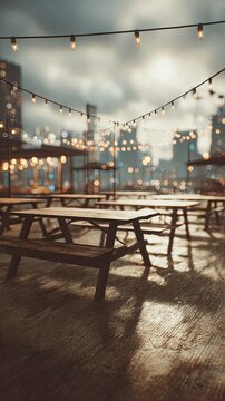 Rooftop picnic tables with string lights and city skyline.