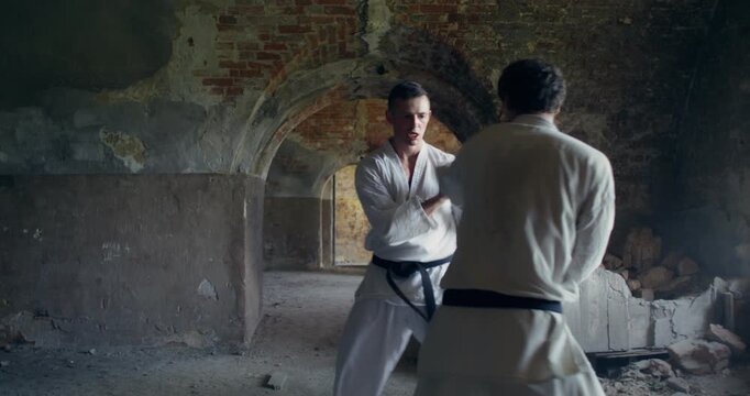Two karate practitioners combine hand and foot strikes during a match.