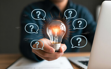 Holding lightbulb with question bubbles