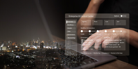 Businessman with laptop operates enterprise AI control center with smart city at night in background. Data governance, workflow orchestration, automation, agentic enterprise, access control technology