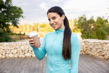 Happy woman holding a shake before starting her routine
