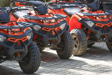 Row of adventurous orange ATV quad bikes parked on paved ground ready for extreme sport and off road driving transport showing powerful and rugged motor vehicles waiting for outdoor action © CoreRock