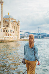 A female tourist stands in front of the Ortakoy Mosque and Martyrs' Bridge on July 15.