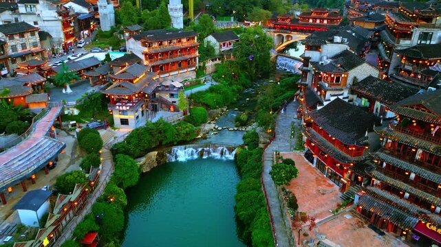 Aerial view of the historic Furong Ancient Town, with its traditional architecture and waterways, creating a vibrant tapestry of color, Xiangxi Tujia, China.