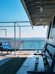 Perspective view of empty blue seats on a ferry boat deck
