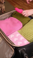 A woman puts an intimate toy in a suitcase with her belongings.