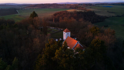 Aerial view of St. Wenceslaus Church in Habrina, Czech Republic, at golden hour.