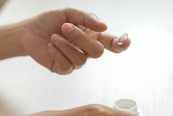 Hand holding a contact lens carefully.
