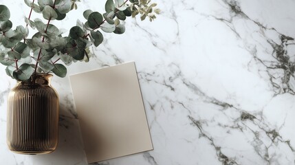 Gold vase with eucalyptus and blank card on marble