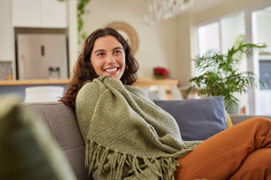 Beautiful woman under green blanket in a cozy home
