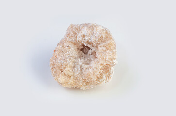 Close-up view of a rough, pale geode with a hollow crystalline center on a white background
