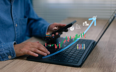 Business professional using laptop and smartphone with digital stock market chart rising arrow, representing investment growth, financial analysis, trading strategy, fintech wealth management