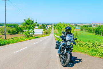 Obraz premium 北海道へツーリング 天に続く道とオートバイ