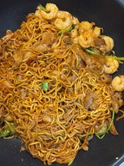 Dry-fried instant noodles with shrimp in a pan.