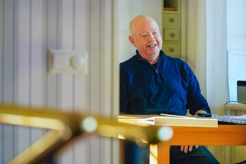Confident relaxed dialogue with an older man smiling during a calm indoor conversation at a table,...