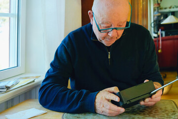 Quiet independence and mindful technology of senior lifestyle  using a portable radio , focused attention and simple interaction reflecting confidence with everyday devices in retired age.