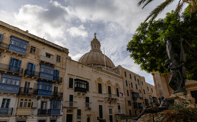 Narrow old streets with windowed buildings and colorful balconies on the streets of Valletta, Malta.