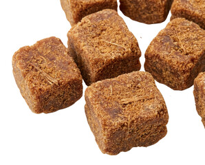 A close-up of traditional ginger brown sugar cubes. The fibrous, unrefined blocks are isolated on a solid black background, highlighting their texture.